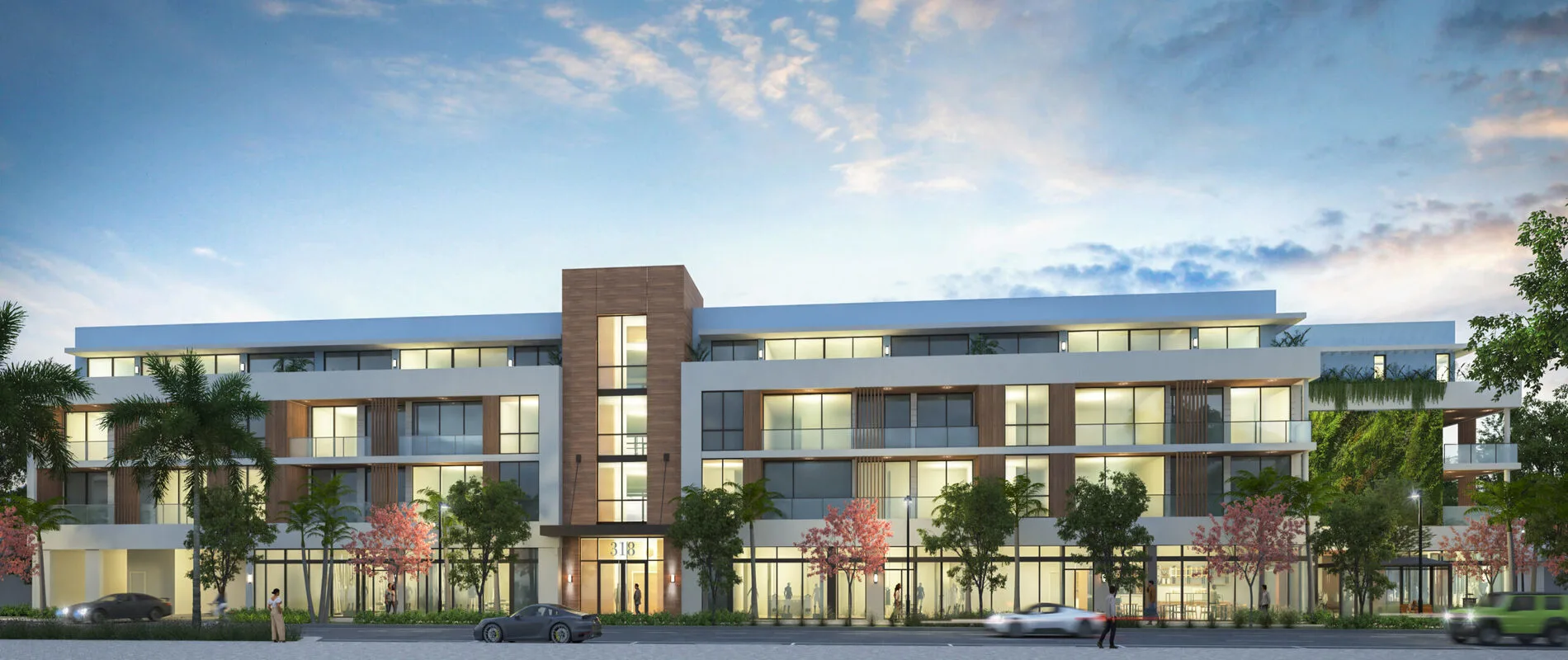 Evening view of Onix Delray, a four-story condo featuring wood accents, glass balconies, and greenery in downtown Delray Beach.